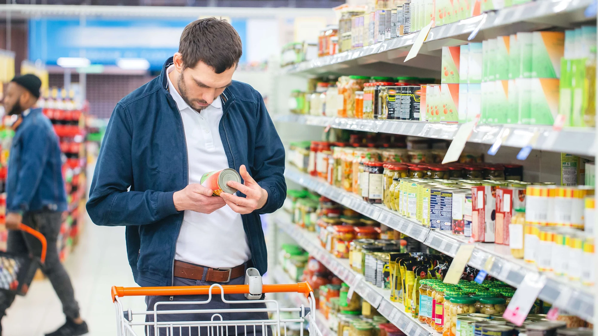 Person in supermarket looking at tin