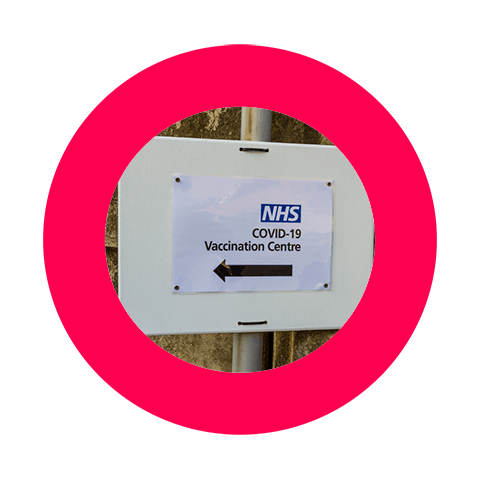 Image of a sign for COVID-19 vaccination centre in the Nectar360 pink logo
